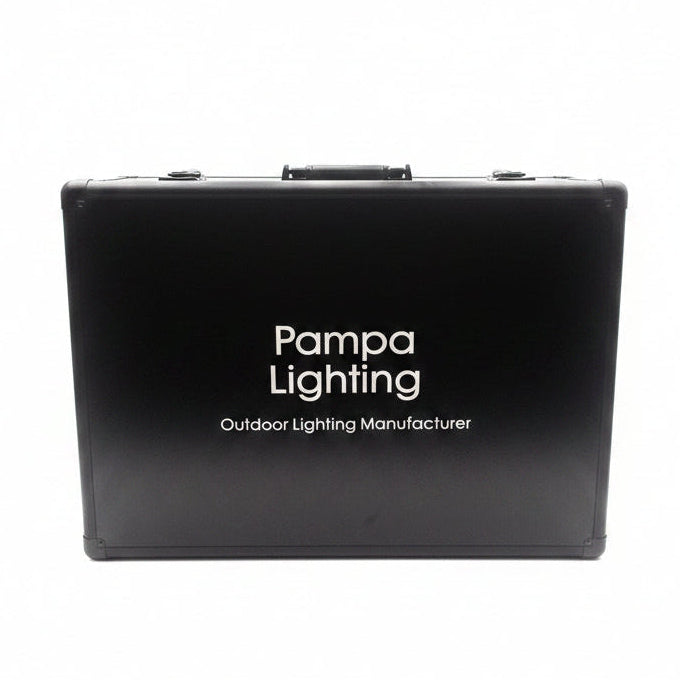 A black hard carrying case with a handle and latches, featuring the white text 'Pampa Lighting Outdoor Lighting Manufacturer' on the front, photographed against a bright white studio backdrop with a softbox.