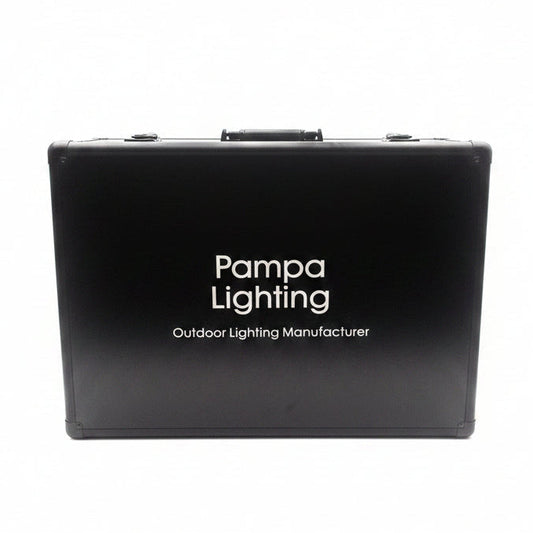 A black hard carrying case with a handle and latches, featuring the white text 'Pampa Lighting Outdoor Lighting Manufacturer' on the front, photographed against a bright white studio backdrop with a softbox.